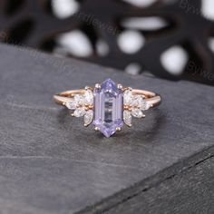 an amethorate and diamond ring sitting on top of a box