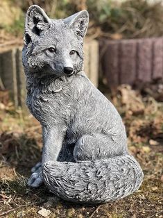 a statue of a fox sitting on the ground