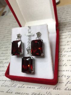 "Earrings & Necklace Set Design#5 Made to Order Red Garnet CZ Earrings (E5) This is a brand new beautiful Art Deco/Edwardian filigree sterling silver pair of red garnet cubic zirconia (CZ) earrings. Each lovely faceted rectangle gemstone is 15mm x 10mm in size each. The earrings are marked 925 for sterling. The earrings are 1\" long with post backs, and approximately 1 and 1/4\" long with hooks. These amazing earrings are pure style and grace. You can dress up or down, it's the perfect state Elegant Jewelry With Rectangular Pendant And Matching Earrings, Red Rectangular Jewelry For Formal Occasions, Square Cut Jewelry With Matching Earrings For Gift, Rectangular Crystal Jewelry For Formal Occasions, Rectangular Pendant Jewelry With Matching Earrings As Gift, Crystal Jewelry With Rectangular Stone For Gift, Red Square Cut Jewelry For Formal Occasions, Formal Rectangular Crystal Jewelry, Silver Jewelry With Rectangular Pendant And Matching Earrings