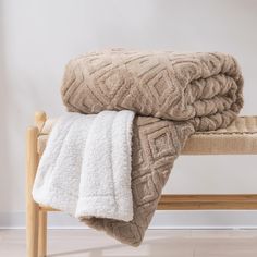 two blankets folded on top of a wooden bench