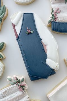 some decorated cookies are laying on a white table with blue and pink decorations around them