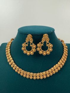 This exquisite piece of craftsmanship comes from our Traditional collection. Finish: 24 grams gold finish Necklace Fastening: Adjustable Dori Earring Fastening: Push Back Contains: 1 necklace, 1 pair of earrings Gold Chandbali Earrings For Wedding, Gold Chandbali Earrings For Marriage, Gold Temple Jewelry Earrings For Marriage, Festive Gold Earrings For Marriage, Gold Earrings For Marriage And Festive Seasons, Gold Necklaces With Elegant Design For Anniversary, Gold Earrings With Intricate Design For Wedding, Antique Gold Elegant Temple Necklace For Wedding, Gold Chandbali Temple Jewelry Necklace