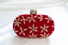 Red Clutch Designer made for Weddings w/ Minimal Zardozi Minimal clutch adorned with simple floral zardozi, bead & sequin embellishments. This red clutch purse evening -wear with a stone-studded closure at the top is a must-have in your wardrobe - a versatile accessory for any party outfit!  Lining: Fabric Color: Red Embroidery: Zardozi, Sequin & Bead Size & Dimensions:  Height - 5 in Width - 8 in Depth - 1.5 in Fits most of the phones. Strap: Detachable shoulder metal chain strap  Closure: Comp Formal Red Embellished Bag, Elegant Red Embellished Evening Bag, Red Embellished Evening Bag, Red Embellished Bag For Formal Occasions, Handmade Glamorous Evening Bag For Wedding, Red Embellished Clutch For Formal Occasions, Traditional Rectangular Coin Purse For Evening, Designer Embellished Wedding Clutch, Designer Embellished Clutch For Wedding