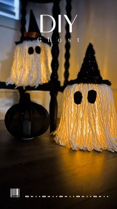 two halloween decorations made out of yarn with eyes and noses on them, sitting on a table