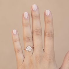 a woman's hand with a ring on it and a flower in the middle