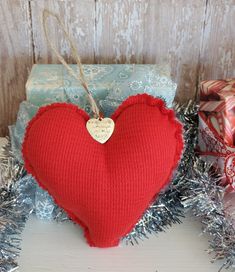 a red heart sitting on top of a pile of presents