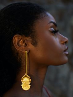 Toronto-based Symbols of Authority specializes in everyday statement jewelry. Inspired by the 16th-century Bini Queen Idia, renowned for her bravery, the Adunni x Idia Bar Earrings boast a shoulder-sweeping bar design. They are handmade from micron-plated brass and etched with the iconic Iyoba ivory mask. Make them the focal point by keeping your other jewelry pieces simple.- Butterfly fastening- Brass, micron-plated gold- Handcrafted by expert artisans using ethically and sustainably sourced materials- Made in Jaipur, India, ships from Canada Ghanaian Gold Jewelry, Temple Jewelry Style Drop Plug Earrings, Ceremonial Drop Earrings, Hand Forged Gold Earrings, Fusion Style Hand Forged Drop Earrings, Yellow Gold Spiritual Earrings, Spiritual Yellow Gold Brass Earrings, Spiritual Hand Forged Dangle Earrings, Spiritual Hand-forged Dangle Earrings