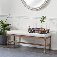 a white bench sitting in front of a mirror and potted plant on the floor