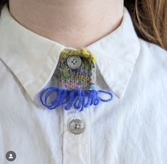 a close up of a person wearing a white shirt with a blue and yellow tie