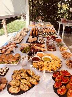 a table full of food that includes breads, crackers and other snacks on it