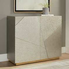 a modern sideboard with an abstract design in the middle and a potted plant on top