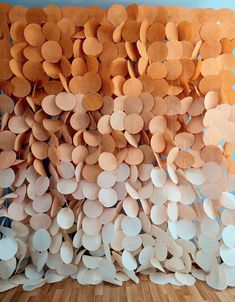 a wall made out of paper plates on top of a wooden floor