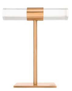 a gold and clear desk lamp on a white background