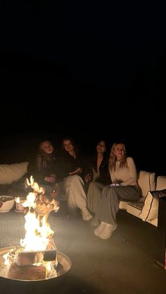 people sitting around a fire pit at night