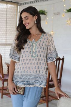 Indian artisan Anchal Ahuja designed this demure top to celebrate the spring season. Crafted from 100% viscose, the short-sleeved blouse features a screen-printed floral motif on an ivory background and embroidery around the neckline. Sequins and bell sleeves with pretty ruffles add a feminine touch to the blouse. Bohemian Half Sleeve Summer Tops, Traditional V-neck Blouse With Printed Motifs, Printed Half Sleeve Tops For Vacation, Bohemian Half Sleeve Blouse For Spring, Bohemian Half Sleeve Blouse For Vacation, Summer Half Sleeve Printed Tops, Printed Half Sleeve Tops For Summer, Summer Half-sleeve Printed Tops, Spring Bohemian Half-sleeve Blouse