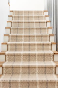 a set of stairs with beige plaid carpet