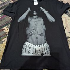 Nwt Tupac T-Shirt Item As Pictured Size Medium Black Graphic Print Tops For Streetwear, Black Cotton Tops With Graphic Print, Hip Hop Style Black Top With Graphic Print, Summer Black Print Cotton Tops, Casual Black Print Tops For Streetwear, Cotton Tops With Black Screen Print, Black Pre-shrunk Tops For Streetwear, Casual Pre-shrunk Black Shirt, Black Letter Print Tops For Streetwear