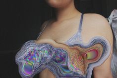 a woman with holographic paint on her chest