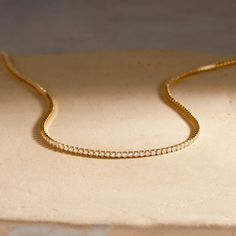 This Mini Tennis Necklace is the perfect accessory for any tennis lover. With CZ stones set in gold vermeil, it adds a touch of elegance to any outfit. Game, set, match - your style game will always be on point with this unique piece. Available in 14k gold vermeil 16" tennis chain with 2" extender 2mm White CZ Lobster claw closure Protected with an anti-tarnish barrier SKU: BYN1507 Game Set Match, Tennis Jewelry, Tennis Chain, Tennis Necklace, Monogram Initials, Cz Stone, Turquoise Jewelry, Birthstone Jewelry, Ring Bracelet