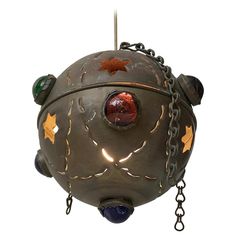 a metal object with chains hanging from it's sides and an animal face on the front