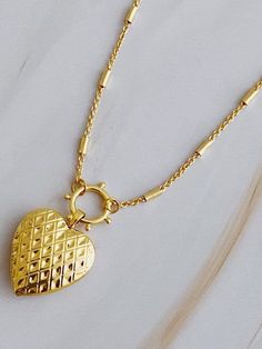 Add a touch of edge to your style with the Patterned Heart Open Locket Necklace. The intricate design pairs perfectly with the delicate heart locket, creating a one-of-a-kind accessory. Ideal for any occasion, the dainty chain adds a subtle touch. Color: Gold Made of: 18k gold plated brass, Lead and nickel-free Brand: Ellison and Young Includes: x1 Necklace Length: Approximately 16" with a 2" extender Elegant Heart Shaped Charms Necklace, Elegant Heart-shaped Charms Necklace, Elegant Heart-shaped Necklace With Charms, Elegant Heart-shaped Charm Necklace, Elegant Heart Pendant Locket Necklace With Adjustable Chain, Heart Shaped Dainty Locket Necklace With Delicate Chain, Dainty Heart Locket Necklace With Delicate Chain, Elegant Double Heart Locket Charm Necklaces, Elegant Heart Locket Charm Necklace