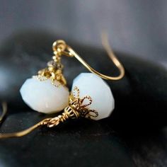 These simple yet elegant handmade white opal crystal earrings are created in a minimal style with a vintage twist to a classic look.   I combined pretty white alabaster opaque faceted glass crystals and layers of gold plated caps and beads.   Dangle beautifully from gold plated hook ear wires.   Perfect anytime!  Great to wear for the office, or everyday.   Pretty boho bridal earrings or other wedding party jewelry.   These dangle earrings go with everything and will make a thoughtful handmade gift for the special person in your life. ♛  Earrings Length:  approx. 1 1/4" inches long  ♛  Earrings Width :  approx. 1/2" inches wide ♛  Crystal Glass Rondelle :  12x8mm // 1/2" wide Select your favorite ear wires from the drop down menu [see ear wires examples in last photo]. Ready to ship, thoug Dainty Opal Earrings For Wedding, Wire Wrapped Crystal Drop Earrings For Wedding, Adjustable White Crystal Earrings For Gift, Delicate White Dangle Crystal Earrings, Wedding Crystal Drop Earrings Wire Wrapped, Wedding Wire Wrapped Crystal Drop Earrings, Delicate Moonstone Earrings For Wedding, Dainty White Teardrop Crystal Earrings, Delicate Moonstone Wedding Earrings