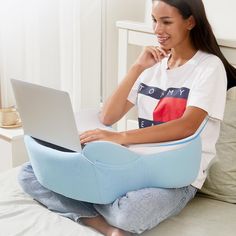 a woman sitting on a bed using a laptop computer