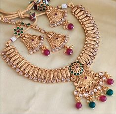 Classic gold Polki plated necklace set. The rajawadi style set has gorgeous deisgn and finished with red n green stones. The set comes with matching maagtikka. The set is done with brass and alloy mixed with micro gold polished. Also known as one gram gold polish. Comes with matching earrings. There is dori on the back to adjust it around the neck. The real look alike necklace set. **P.S: Please ask any question if you have related to this product before purchasing as returns for size, Color,wei Pakistani Necklace, Indian Necklace Set, Polki Necklace Set, Polki Necklace, Indian Necklace, Green Stones, Classic Gold, Gold Polish, Brass Jewelry