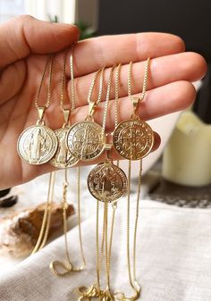 As one of the most identifiable religious coins,  Our double sided, traditional Saint Benedict pendant has a rich religious history and a coveted meaning. Popularly known as the Saint of protection from evil.  ✦ Gold filled Box, Ball, or Figaro chain measures 20 inches / 18K Gold Filled ✦ Two-sided pendant measures .75 inches / 18K GF Our jewelry is hypo allergenic and tarnish resistant, lasting many years. Spiritual Coin-shaped Medallion Necklace With Locket, Spiritual Gold Plated Coin Pendant Charm Necklace, Spiritual Gold Plated Charm Necklace With Coin Pendant, Spiritual Coin Medallion Necklace With Locket, Spiritual Medallion Coin Necklace With Locket, Gold Amulet Charm Necklace With Coin Pendant, Gold Charm Necklace With Coin Pendant, Spiritual Gold-plated Coin Jewelry, Spiritual Gold-plated Engraved Coin Necklace