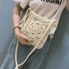 a woman is holding a crocheted purse