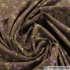 a close up view of a fabric with flowers and leaves on the side, in brown