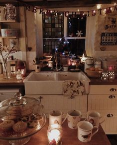 a kitchen counter topped with lots of cups and saucers next to a sink filled with cookies