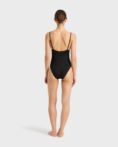 The Emilia One Piece in Black is a classic and elegant swimsuit featuring a triangle bra, adjustable rouleau straps, under-bust support and a medium to high leg line with regular bottom coverage. Emilia is made from our unique Singuleur® fabric that moves with the body like a second skin. Luxury fabric sustainably made in Italy. Garment ethically and sustainably made in Australia. Elegant Swimwear With Lined Body And Minimal Stretch, Black Swimwear With Built-in Bra And Low Back, Adjustable Straps Second-skin Swimwear For Swimming, Backless Swimwear For The Beach, Elegant Minimal Stretch Swimwear For Poolside, Black Swimwear With Adjustable Straps And Minimal Stretch, Black Second-skin Swimwear With Low Back, Black Second-skin Low Back Swimwear, Black Second-skin Low-back Swimwear