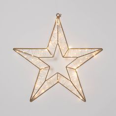 a lighted star ornament hanging on a wall with lights in the shape of a star