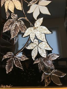 a close up of a metal object with leaves on it