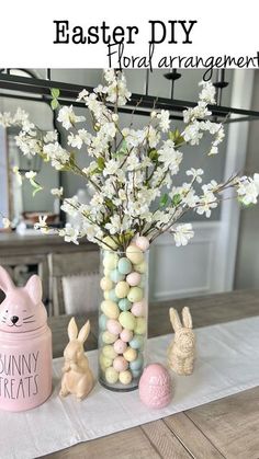 a vase filled with eggs and flowers on top of a table next to other decorations