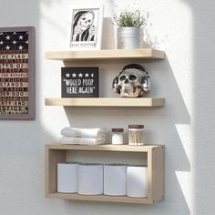 two wooden shelves with white towels and other items on them, against a white wall