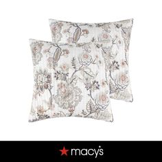 two pillows with floral designs on them, one is white and the other is blue