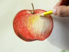 someone is drawing an apple with colored pencils