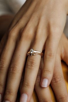 a woman's hand with a diamond ring on her finger