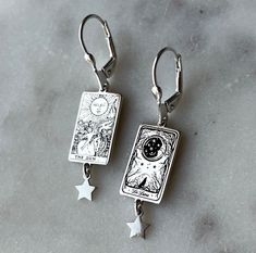 La Luna and The Sun Earings all maden 925 sterling silver . Tarot card silver earrings . Inspired by Tarot cards . Personalization : Just write the two cards you want in the note section when placing your order . If not specified in the note, Luna and sun cards in the images will be sent. La luna illustration REGISTERED LINERWORKS DESIGN. Jewelry Care *Keep you pieces dry and free from moisture *Avoid applying lotions, perfumes or other sprays while you are wearing your jewelry. *Wear your piece Celestial Silver Jewelry For Gifts, Celestial Style Silver Jewelry For Gifts, Celestial Drop Earrings Gift, Celestial Style Drop Earrings As Gift, Mystical White Gold Jewelry Gift, Silver Engraved Earrings For Gift, Engraved Silver Earrings As Gift, Symbolic Star Shaped Earrings For Gift, Celestial Nickel-free Earrings As Gift