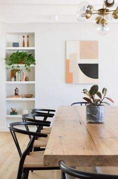 a dining room table with chairs and a potted plant