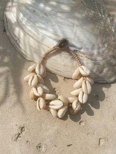 Introducing our new beach accessory: the OCEAN COWRIE SEASHELL BRACELET. Crafted with natural shells sourced from the depths of the ocean in Thailand, this statement piece beautifully captures the essence of the sea. Each shell is carefully combined to create a captivating and unique representation of oceanic beauty. Perfect for beach outfits, honeymoons, resort wear, or gift for your love ones, this choker necklace is a versatile addition to your wardrobe. What sets it apart is our commitment to sustainability and our dedication to working directly with our makers. By choosing this bracelet, you're not only enhancing your style but also supporting ethical craftsmanship and caring for the world. Elevate your beach look with this stunning, eco-friendly accessory and feel good about your imp White Bohemian Shell Bracelet, Beachy Shell Bracelet Jewelry, White Oyster Bracelet Jewelry For The Beach, Shell Jewelry Bracelet For Vacation, Cowrie Shell Beaded Bracelets As Gift, Shell Bracelet Jewelry For Vacation, Beaded Shell Strand Bracelets, Shell Bracelet For Beach, Adjustable Shell Bracelets With Ocean-inspired Style