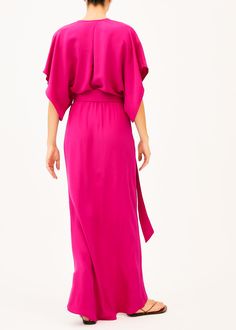 The Norma is a low v neck pink full length dress that features a plunging neckline with two concealed snaps to change the length of the neckline, half split sleeves, an elastic waist with a long wrap belt, and an asymmetrical skirt. This elegant silhouette is perfect for any formal event. Our pieces are majority made to order ensuring that no fabric is wasted and energy is conserved. Once the order is placed we will notify you when it has been made and is shipped out (Approximately 2-3 weeks). C Pink Belted V-neck Midi Dress, Pink V-neck Dress With Side Slits, Chic Belted Maxi Dress With Surplice Neckline, Chic Pink Maxi Dress With Side Slits, Pink V-neck Surplice Dress For Formal Occasions, Evening V-neck Maxi Dress With Tie Waist, Pink V-neck Surplice Neckline Formal Dress, V-neck Maxi Dress With Tie Waist For Evening, Pink Chic Maxi-length Wrap Dress