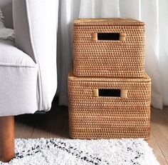 two wicker baskets sitting on the floor next to a couch