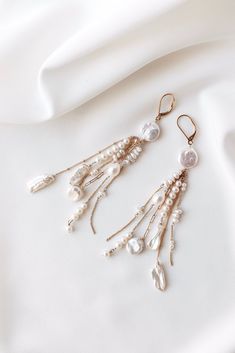 Elevate your bridal ensemble with these exquisite long dangly boho luxury earrings. Handcrafted with meticulous care and quality materials, these earrings feature a stunning combination of 14k filled gold chain and a curated mix of freshwater pearls, ensuring a unique and timeless design. The graceful movement of the chains adds a touch of sophistication, the perfect stylish wedding jewelry for your special day.   The careful craftsmanship ensures both beauty and durability, making them a cheris Delicate Dangling Beads Earrings For Wedding, Bohemian Bridal Earrings For Wedding, Elegant Long Drop Chandelier Earrings With Dangling Charms, Silver Jewelry With Dangling Charms For Wedding, White Long Drop Chandelier Earrings For Wedding, White Long Drop Single Bridal Earring, Long Drop Pearl Earrings With Dangling Beads For Wedding, Delicate Long Drop Linear Earrings For Wedding, Delicate White Jewelry With Dangling Beads