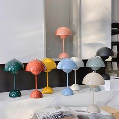 several different colored lamps are on display in a room with white walls and flooring