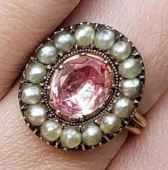 This is one of my most favorite pieces I have ever acquired. It is extremely rare. A perfect example of an exquisite Georgian Imperial Pink Topaz Ring. It's impossible to give an exact carat weight because it is foiled backed as most rings were during this time period. It is a substantial stone (to say the least.) The pink is like none other. Set with sterling silver and yellow gold, the ring is in absolutely pristine condition. I took it to my gemologist and bench worker. All of the seed pearls Antique Jeweled Jewelry For Anniversary, Victorian Oval Pearl Ring With Gemstone, Victorian Pearl Ring Gemstone Gift, Victorian Pearl Ring With Gemstone For Gift, Antique Cabochon Pearl Ring For Anniversary, Victorian Pearl Ring Gift, Antique Pearl Ring With Cabochon For Anniversary, Victorian Style Pearl Ring Gift, Vintage Cabochon Pearl Ring For Wedding