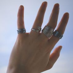 a person's hand with two rings on it and one ring in the air