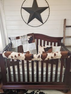 a baby crib with a star on the wall above it and some pillows in front of it